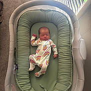 Addisyn joined the competition — help win amazing prizes! baby, newborn, sleeping, bassinet, onesie, rainbow_pattern, infant, bedroom, carpet, window, blinds, light, green_cushion, sleep, cozy, child, person, indoor, resting, soft
