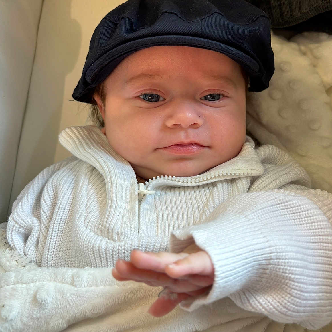 Lior a rejoint le concours — aidez-le/la à gagner de superbes lots ! baby, blanket, cap, child, closeup, comfort, cozy, cute, expression, face, hand, hat, indoor, infant, knitwear, person, portrait, soft, sweater, young