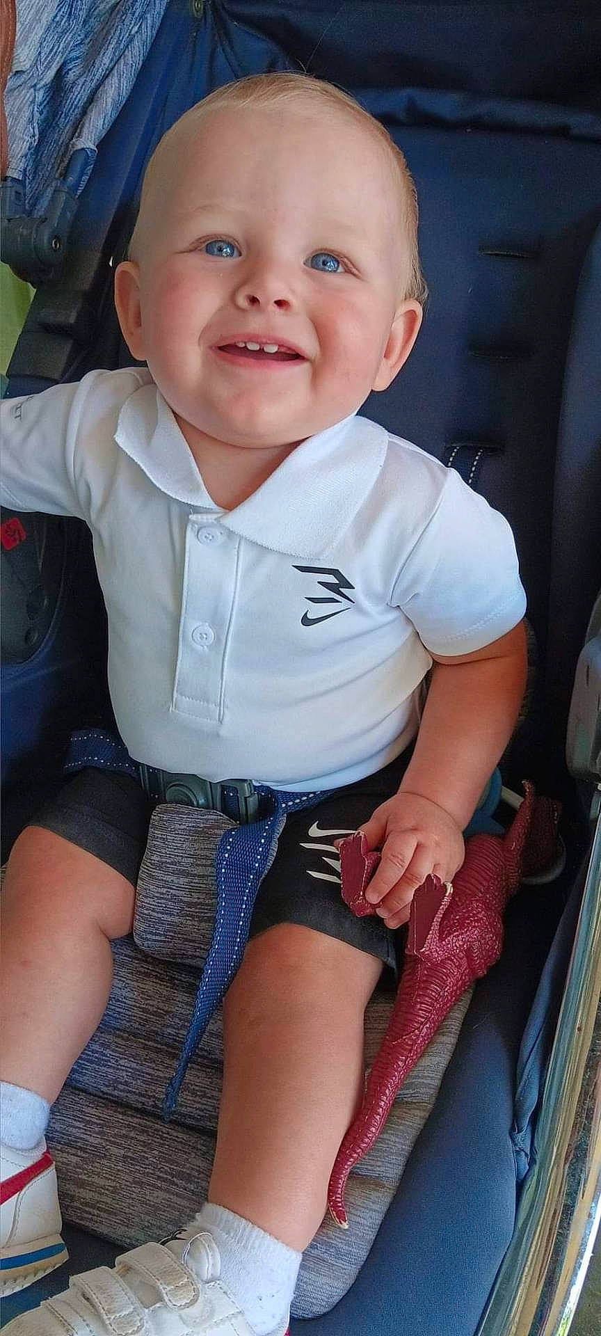 Maverik is registered to the contest to win money with this photo: baby, clothing, coat, face, footwear, happy, head, hosiery, jacket, jeans, pants, person, photography, portrait, shoe, shorts, sitting, sneaker, sock, t_shirt