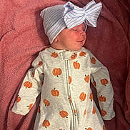 Charlotte is registered to the contest to win money with this photo: baby, blanket, bow, child, clothing, cozy, cute, hat, indoors, infant, newborn, onesie, pink, portrait, pumpkin_pattern, resting, sleeping, soft, toddler, warm