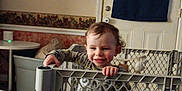 Joseph joined the competition — help win amazing prizes! toddler, child, baby_gate, smiling, indoor, toy, table, door, wall, furniture, curtain, floor, plastic, playpen, hands, person, home, happy, room, grip