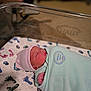 newborn, baby, swaddle, hat, sleeping, bassinet, hospital, blanket, footprint_pattern, infant, cute, peaceful, wrapped, bed, soft_focus, person, indoors, resting, toddler, sleep