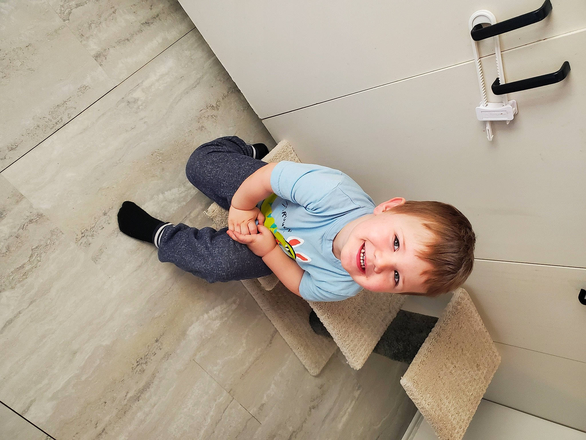 Jacob participe au concours pour gagner de l'argent avec cette photo : baby, baby_toddler_clothing, child, comfort, elbow, floor, flooring, fun, hardwood, joint, joy, laminate_flooring, person, room, sitting, smile, t_shirt, toddler, varnish, wood