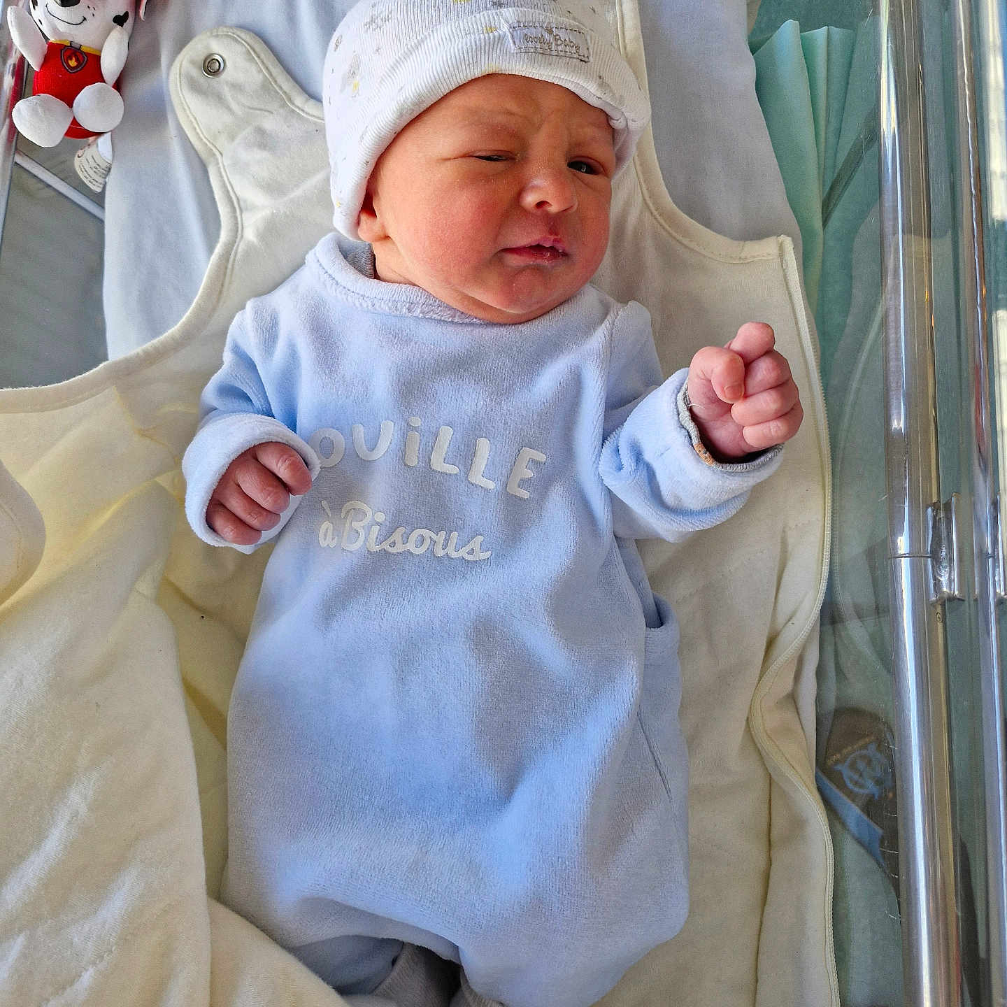 Lyam a rejoint le concours — aidez-le/la à gagner de superbes lots ! baby, baby_outfit, bassinet, bed, blanket, child, clothing, cute, expression, hat, hospital, hospital_room, indoors, infant, lying_down, newborn, person, plush_toy, sleepwear, soft_toys