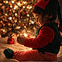 Vaayu is registered to the contest to win money with this photo: child, baby, christmas, holiday, elf_costume, striped_pajamas, red_and_green, lights, bokeh, decorations, tree, cozy, warm_lighting, indoors, cute, profile, sitting, face, soft_focus, festive