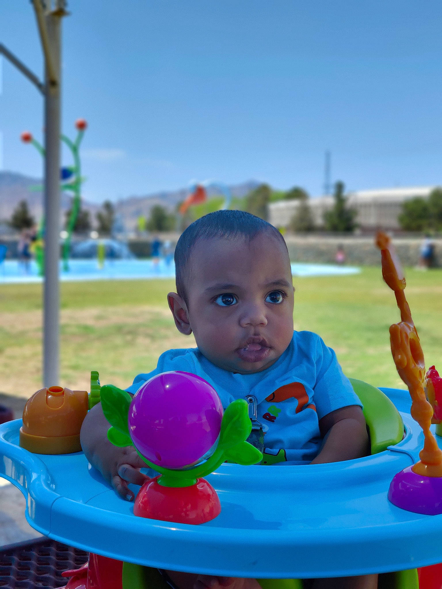 Kaylen joined the competition — help win amazing prizes! baby, baby_playing_with_toys, baby_toddler_clothing, blue, child, city, facial_expression, fun, grass, happy, human_settlement, leisure, outdoor_play_equipment, people, person, public_space, recreation, sitting, sky, summer