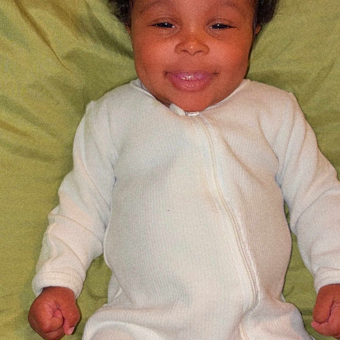 Kennedi Antoine is registered to the contest to win money with this photo: baby, child, cozy, curly_hair, cute, face, green_pillow, hands, happy, indoor, infant, lying_down, onesie, person, pillow, portrait, resting, sleepwear, smile, young_child