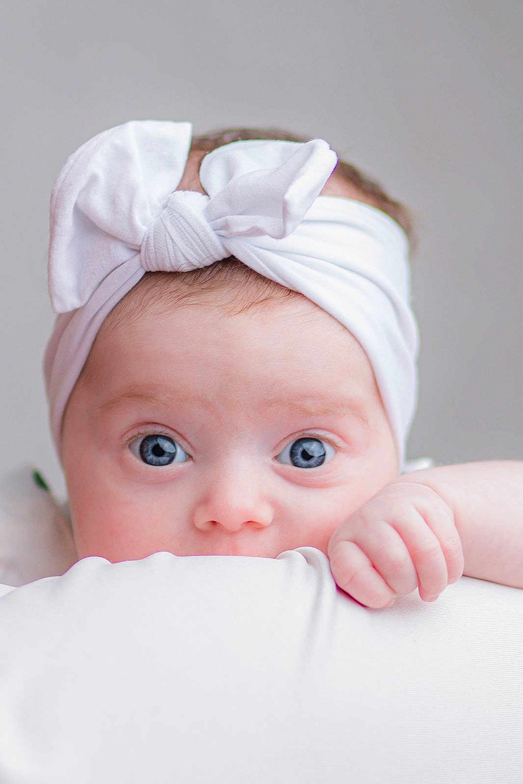 Lola a rejoint le concours — aidez-le/la à gagner de superbes lots ! baby, child, face, blue_eyes, headband, white_bow, hand, soft_light, closeup, portrait, cute, infant, skin, expression, looking, young, adorable, innocent, baby_girl, peeking