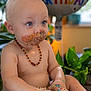 baby, birthday, cake, messy, frosting, blue_eyes, diaper, necklace, balloon, celebration, indoor, plants, child, happy, cute, portrait, sitting, food, colorful, smudged