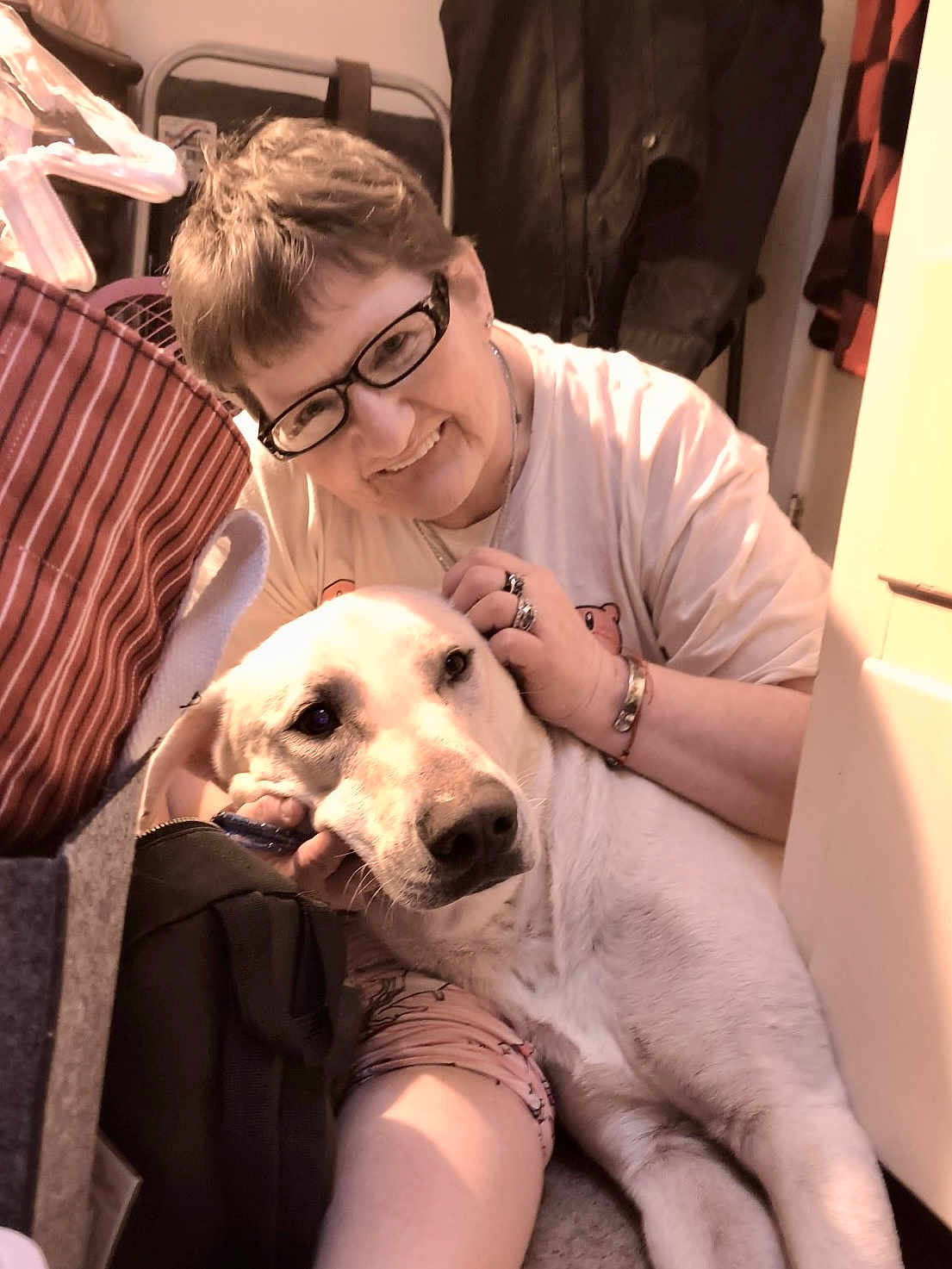 Cyder joined the competition — help win amazing prizes! person, dog, glasses, smile, indoor, pet, light, casual_clothing, floor, coat, jewelry, short_hair, hand, face, companion, comfort, relaxation, domestic, friendly, affection