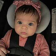 Marie joined the competition — help win amazing prizes! baby, infant, car_seat, headband, pink_clothing, straps, child, face, eyes, portrait, sitting, cute, young_child, safety, seat_belt, clothing, hand, expression, indoors, person