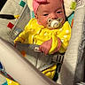 baby, infant, child, portrait, pacifier, pink_bow, yellow_outfit, polka_dots, bouncer, baby_seat, sitting, awake, face, hands, indoor, colorful, textile, harness, nursery, closeup