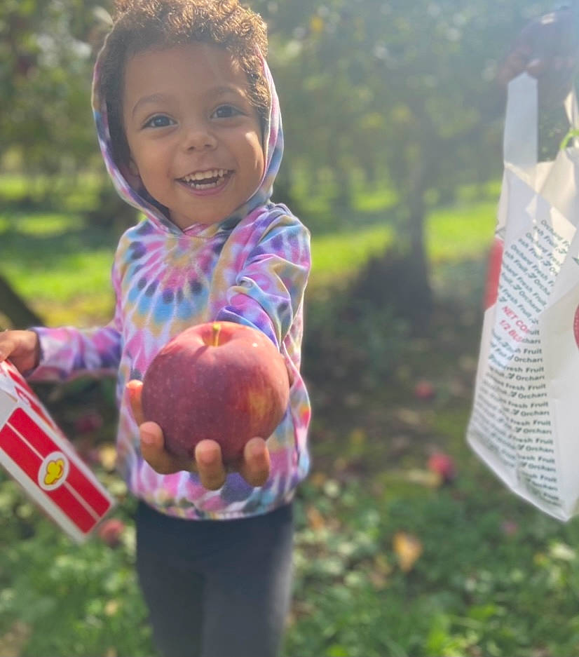 Myla is registered to the contest to win money with this photo: child, face, finger, fun, grass, hand, happy, joy, lawn, leaf, leisure, liquid_bubble, people_in_nature, person, plant, recreation, sitting, smile, soil, toddler