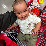 Landon joined the competition — help win amazing prizes! baby, cartoon, child, clothing, eyes, face, grocery_store, happy, indoor, infant, metal, pants, parent, portrait, red, shirt, shopping_cart, sitting, smiling, supermarket