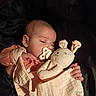 baby, infant, child, sleepy, pacifier, stuffed_animal, bunny, comforter, blanket, bed, indoor, portrait, cuddling, hands, peach_clothing, warm_lighting, cozy, relaxed, closeup, photography