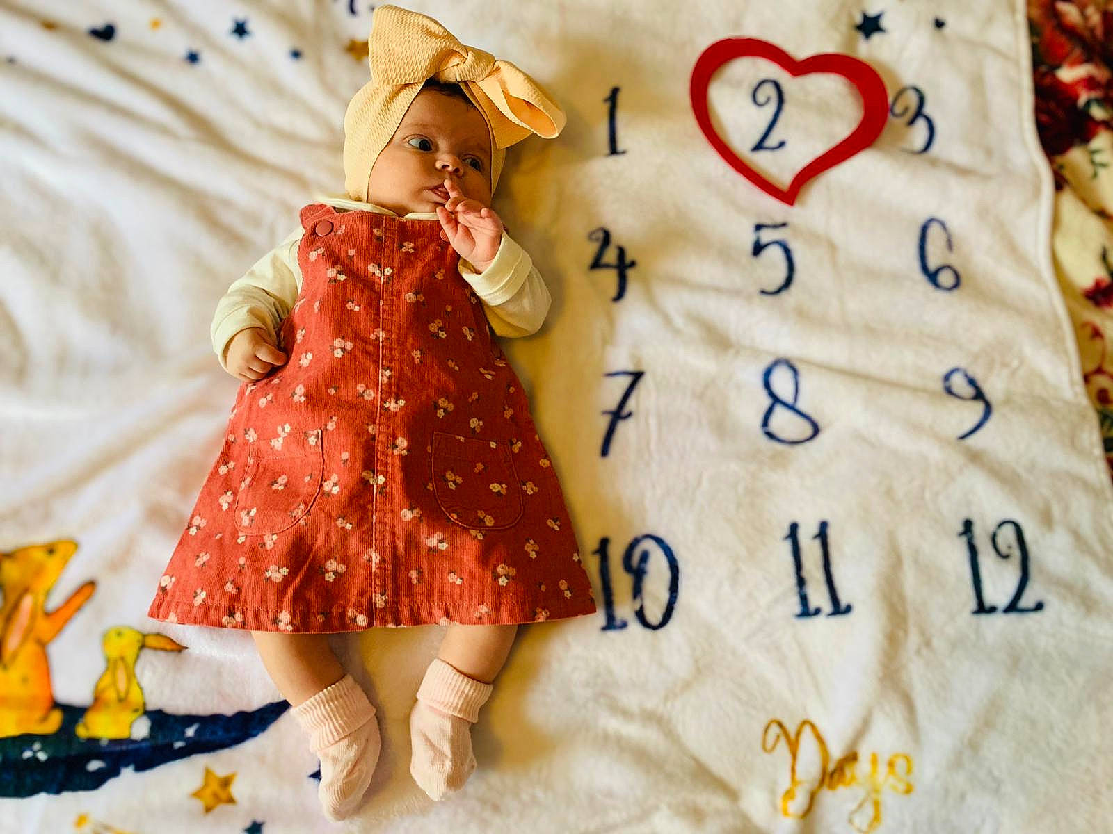 Giulia is registered to the contest to win money with this photo: baby_toddler_clothing, bedding, child, day_dress, doll, dress, facial_expression, fashion_design, fawn, font, happy, hat, linens, one_piece_garment, pattern, peach, person, sleeve, sun_hat, textile
