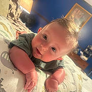 Remington joined the competition — help win amazing prizes! baby, infant, pillow, bedroom, lamp, blue_wall, child, smiling, curious, lying_down, soft_light, cute, patterned_pillow, indoors, home, furniture, portrait, young_child, cozy, sleeping_area