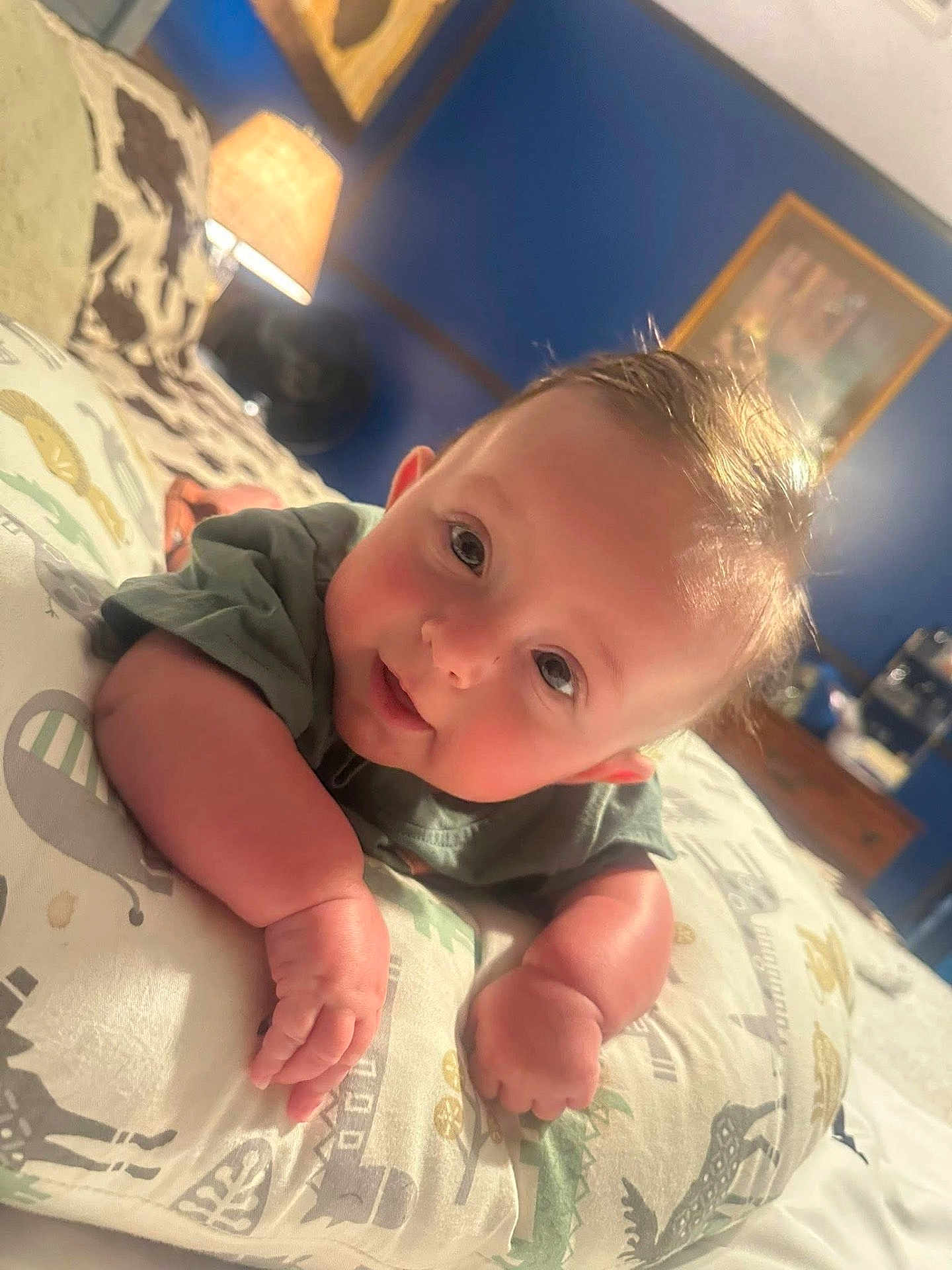 Remington joined the competition — help win amazing prizes! baby, infant, pillow, bedroom, lamp, blue_wall, child, smiling, curious, lying_down, soft_light, cute, patterned_pillow, indoors, home, furniture, portrait, young_child, cozy, sleeping_area
