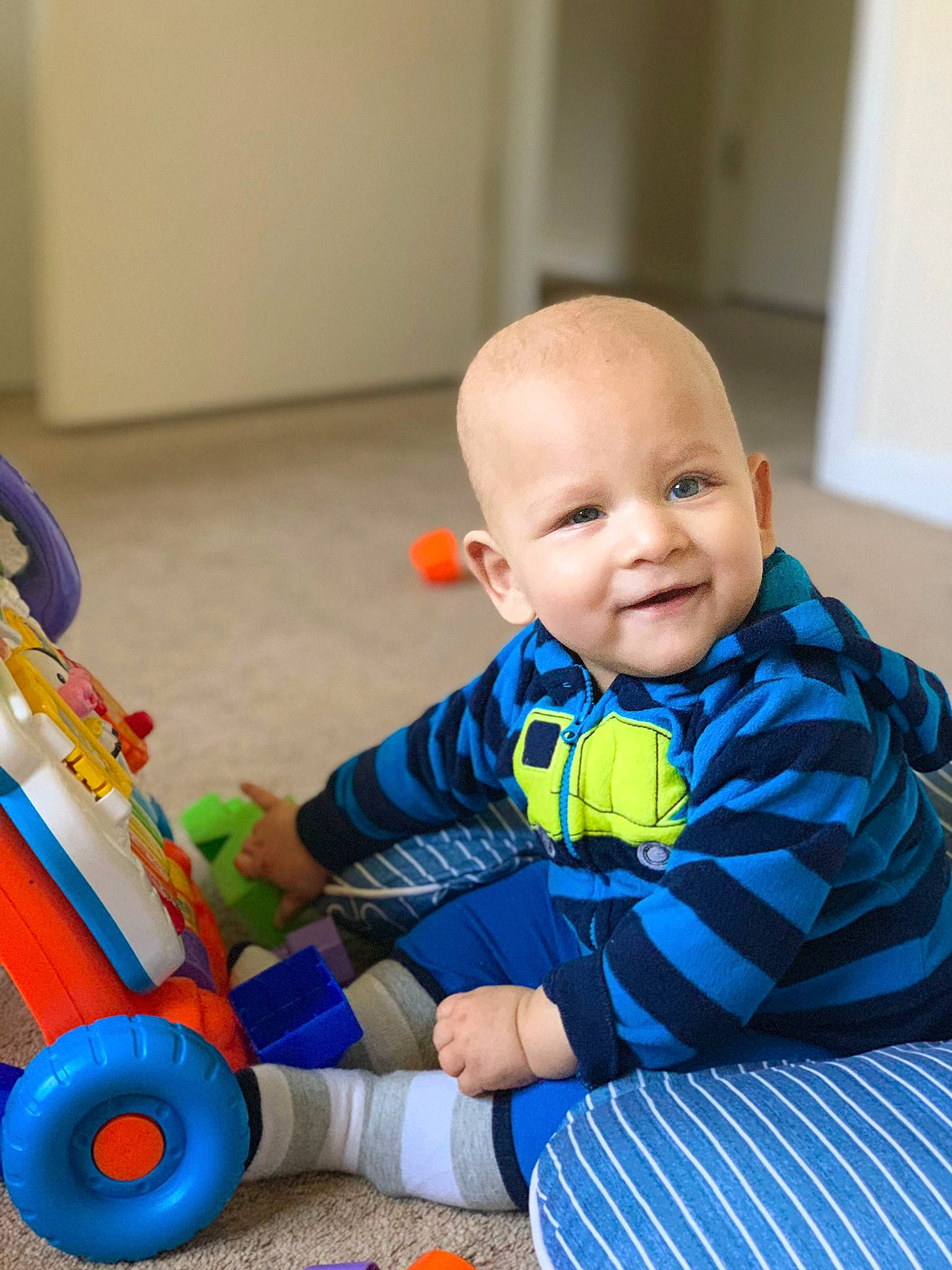 David joined the competition — help win amazing prizes! baby, baby_playing_with_toys, baby_toddler_clothing, child, electric_blue, facial_expression, flooring, fun, happy, joy, person, riding_toy, skin, sleeve, smile, standing, tire, toddler, toy, wheel