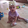 Isabella joined the competition — help win amazing prizes! baby, child, indoor, floor, wooden_floor, toy, sippy_cup, bow, purple_clothing, sitting, curious, face, expression, footwear, shoe, pink_shoe, hand, headband, playtime, room