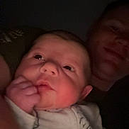 Archer is registered to the contest to win money with this photo: baby, infant, person, face, adult, portrait, closeup, expression, hand, sleepwear, night, dark, cozy, cuddle, smile, skin, head, eyes, family, love