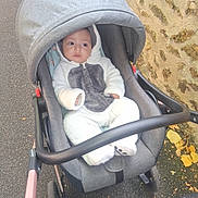 Adam participe au concours pour gagner de l'argent avec cette photo : autumn, baby, casual, child, cozy, curious, cute, footwear, gray, hooded, infant, leaves, onesie, outdoor, pavement, person, soft, stone_wall, stroller, white
