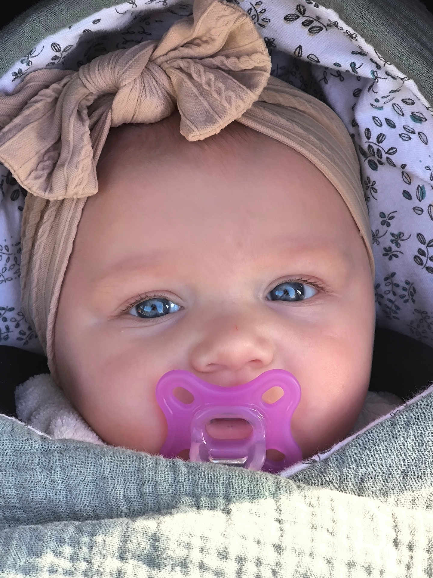 Alma a rejoint le concours — aidez-le/la à gagner de superbes lots ! baby, pacifier, headband, bow, blue_eyes, blanket, close_up, face, infant, cute, wrapped, child, soft_texture, indoors, portrait, skin, small_person, adorable, human, peaceful