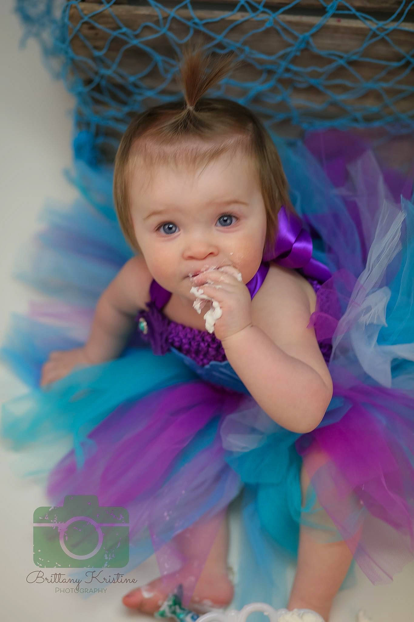 Claire joined the competition — help win amazing prizes! aqua, baby, baby_toddler_clothing, blue, child, day_dress, dress, fashion_accessory, flash_photography, fun, happy, headpiece, iris, magenta, person, pink, purple, sitting, skin, toddler
