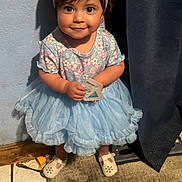 Dalayza joined the competition — help win amazing prizes! toddler, child, girl, dress, headband, smile, indoors, carpet, curtain, wall, floor, shoes, toy, card, person, cute, happy, standing, clothing, portrait