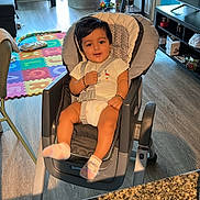 Ansh joined the competition — help win amazing prizes! baby, child, high_chair, socks, playmat, toys, living_room, window, plants, shelf, tv, floor, countertop, smile, seatbelt, rug, sunlight, portrait, furniture, hair