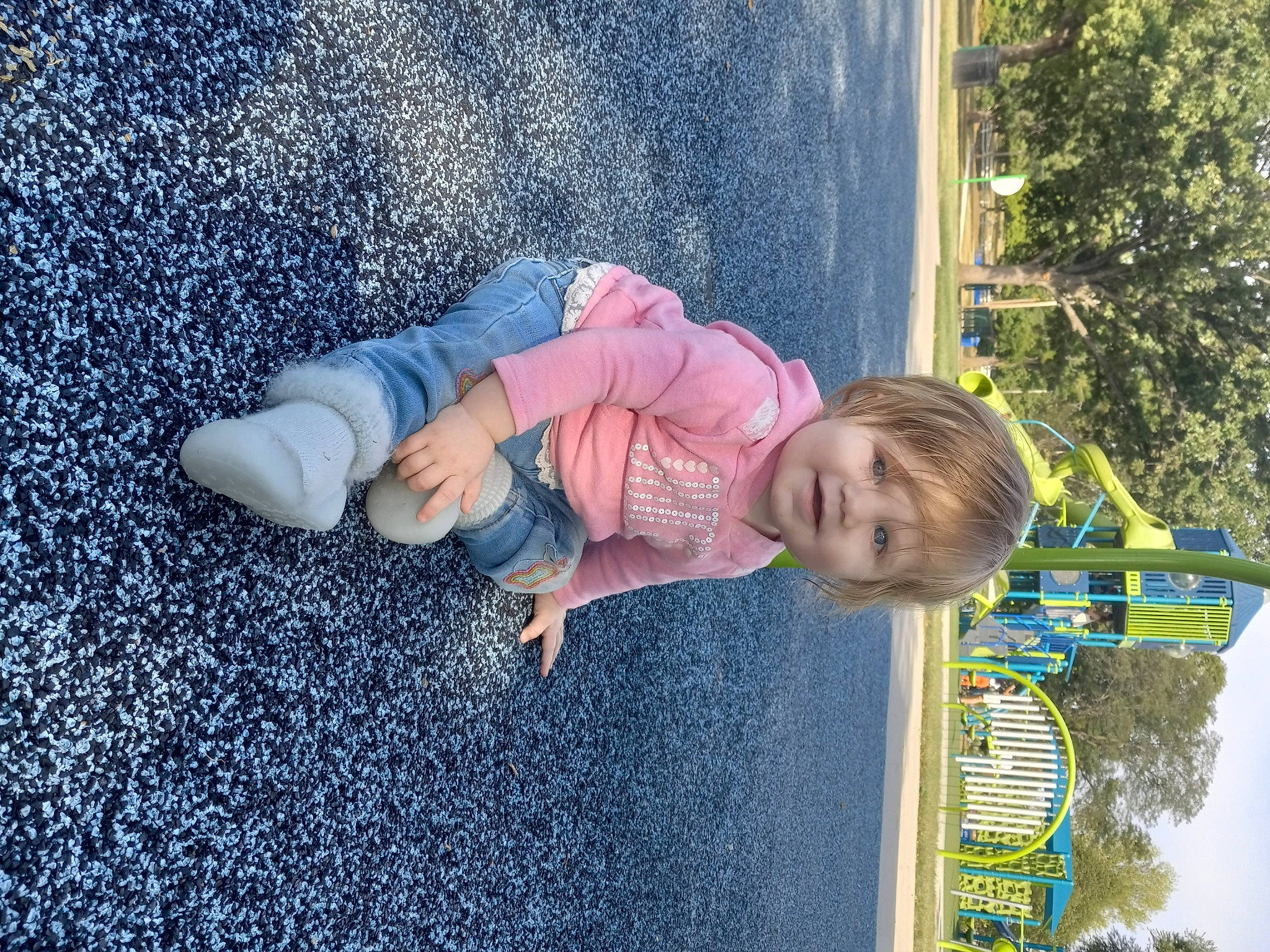 Amber is registered to the contest to win money with this photo: asphalt, baby, baby_toddler_clothing, blue, child, electric_blue, fun, grass, happy, human_body, leisure, people_in_nature, person, plant, play, road_surface, sitting, smile, toddler, tree