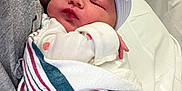 Alexis joined the competition — help win amazing prizes! newborn, baby, infant, hospital, blanket, hat, bow, sleeping, person, arm, clothing, striped_blanket, resting, cute, cozy, indoor, healthcare, caregiver, skin, wrapped