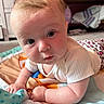 baby, infant, child, play_mat, white_shirt, leopard_print, curious, lying_down, indoors, floor, colorful, cute, portrait, toddler, hands, face, eyes, expression, soft_lighting, home