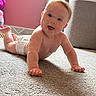 Emily is registered to the contest to win money with this photo: baby, crawling, diaper, carpet, indoor, child, smiling, happy, face, skin, toy, pink_wall, floor, person, infant, head, cute, young_child, expression, home