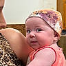 baby, child, infant, hat, colorful, coral_tank_top, leopard_print, adult, arm, face, eyes, indoor, cozy, skin, expression, person, holding, shoulder, closeup, portrait