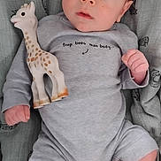 Auguste participe au concours pour gagner de l'argent avec cette photo : baby, infant, toy, giraffe, onesie, blanket, pattern, sock, cute, child, soft, indoors, portrait, lying_down, expression, curious, small_hand, baby_clothes, colorful, peaceful