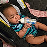 Dexter is registered to the contest to win money with this photo: baby, infant, bottle, feeding, car_seat, blanket, bed, child, person, indoors, clothing, blue, striped, cute, chubby, milk, hand, face, relaxing, comfort