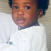 Kamal participe au concours pour gagner de l'argent avec cette photo : casual, child, closeup, curly_hair, cute, expression, face, head_and_shoulders, human, indoor, looking_at_camera, natural, neutral_background, person, portrait, sitting, soft_lighting, white_clothing, young_child, young_person