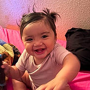 Ayla joined the competition — help win amazing prizes! baby, child, smiling, happy, pigtails, bottle, blanket, pink_bed, indoor, cute, infant, person, sitting, young_child, warm_lighting, cozy, playful, soft_texture, clothing, portrait