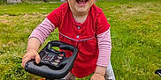 Soleya participe au concours pour gagner de l'argent avec cette photo : toddler, child, smiling, toy_car, outdoor, grass, red_shirt, play, happy, steering_wheel, greenery, nature, person, young_child, vehicle, cute, fun, daylight, casual_clothing, lawn