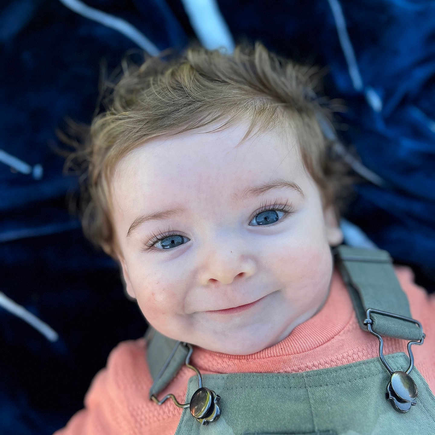 Raiden is registered to the contest to win money with this photo: baby, child, smile, face, blue_eyes, hair, overalls, sweater, clothing, portrait, infant, cute, closeup, happy, lying_down, blanket, fabric, indoor, skin, young