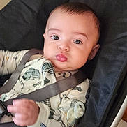 Cole is registered to the contest to win money with this photo: baby, infant, child, face, eyes, onesie, fish_pattern, seatbelt, car_seat, pout, hand, cute, indoor, portrait, skin, head, expression, furniture, clothing, young