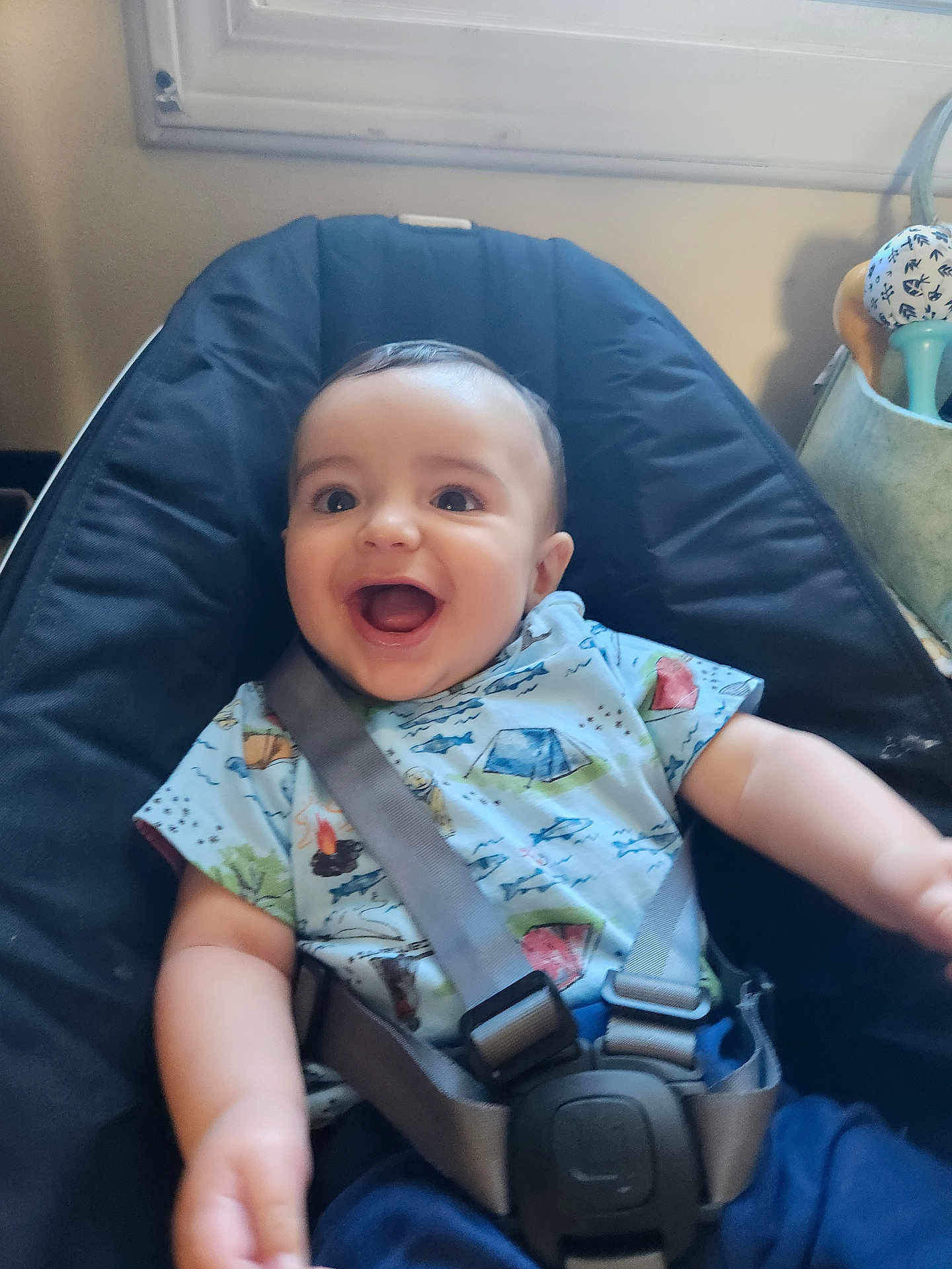 Cole joined the competition — help win amazing prizes! baby, child, smile, happy, infant, sitting, seat, straps, clothing, indoors, window, toy, face, person, blue, black, shirt, happy_face, cute, home