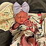 Emereigh is registered to the contest to win money with this photo: newborn, baby, sleeping, blanket, bow, headband, infant, footprints, wrapped, cozy, peaceful, cute, tiny, soft, hands, feet, hospital_band, resting, portrait, indoors