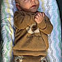 Yasin joined the competition — help win amazing prizes! baby, infant, child, clothing, sweater, pants, bear_hugs, bear_pattern, blanket, pattern, brown, cute, hands, face, eyes, gazing, lying_down, cozy, soft, adorable