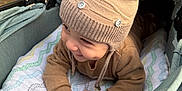 Yasin is registered to the contest to win money with this photo: baby, child, stroller, hat, knit_hat, beige, smiling, cute, blanket, cozy, outdoor, infant, clothing, face, happy, person, portrait, hands, headwear, baby_boy