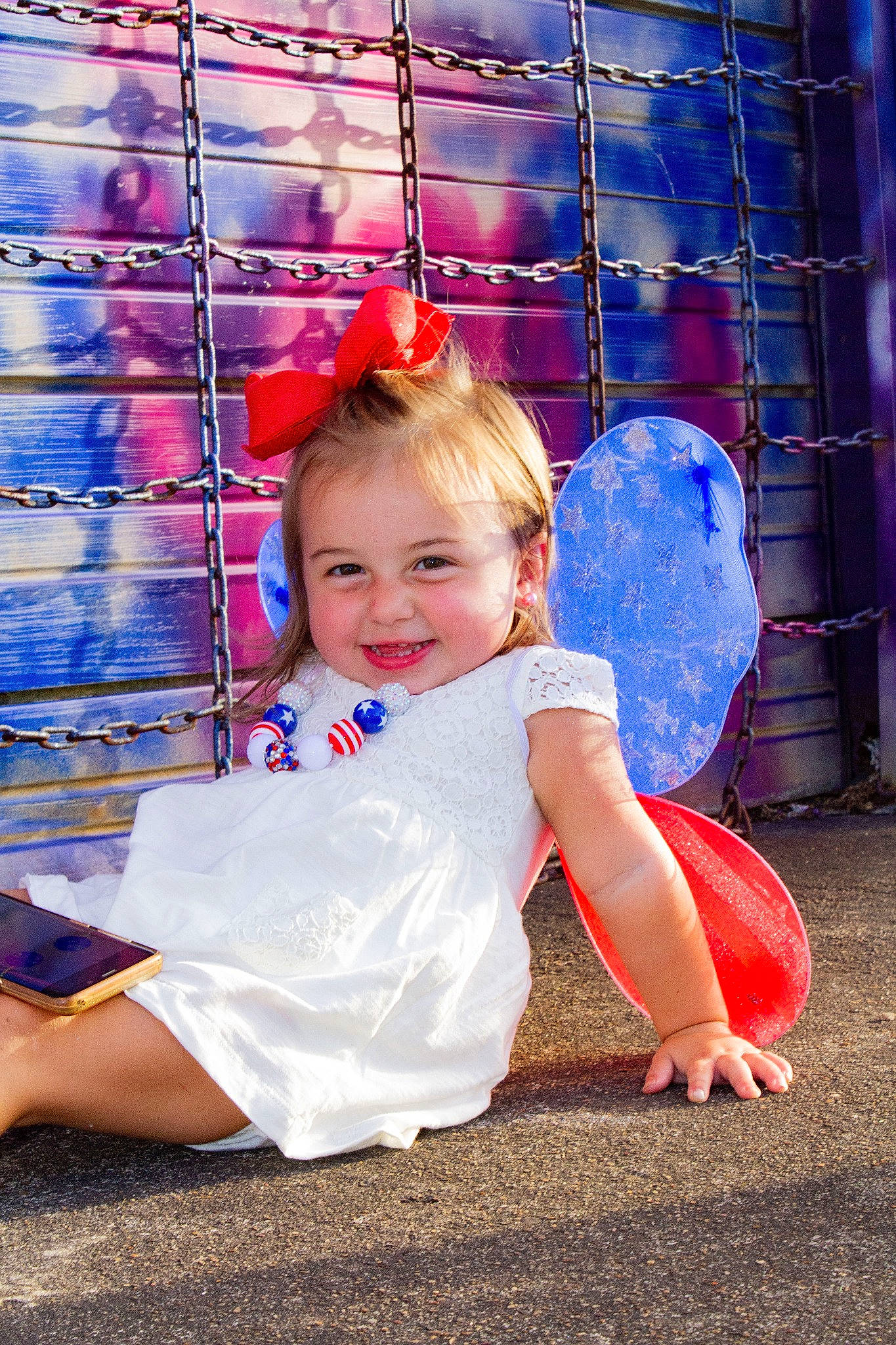 Kynzlee is registered to the contest to win money with this photo: blue, child, child_model, city, fun, happy, human_settlement, joy, outdoor_play_equipment, person, photography, pink, play, playground, public_space, recreation, red, sitting, smile, toddler