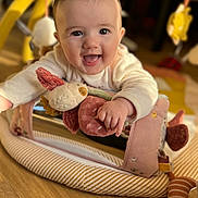 Romane a rejoint le concours — aidez-le/la à gagner de superbes lots ! baby, child, closeup, clothing, crawling, cute, face, hand, happy, indoors, infant, person, play_mat, plush_toy, portrait, smiling, soft_toy, toy, warm_lighting, wooden_floor