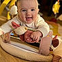 baby, child, closeup, clothing, crawling, cute, face, hand, happy, indoors, infant, person, play_mat, plush_toy, portrait, smiling, soft_toy, toy, warm_lighting, wooden_floor