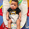 baby, infant, child, bouncer, lion_king, clothing, onesie, face, legs, hands, socks, playmat, colorful, toy, animal_print, indoor, cute, portrait, seat, expression